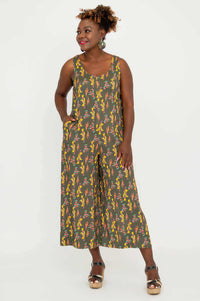Woman in a sleeveless floral bamboo linen jumpsuit with hands in pockets, angled view