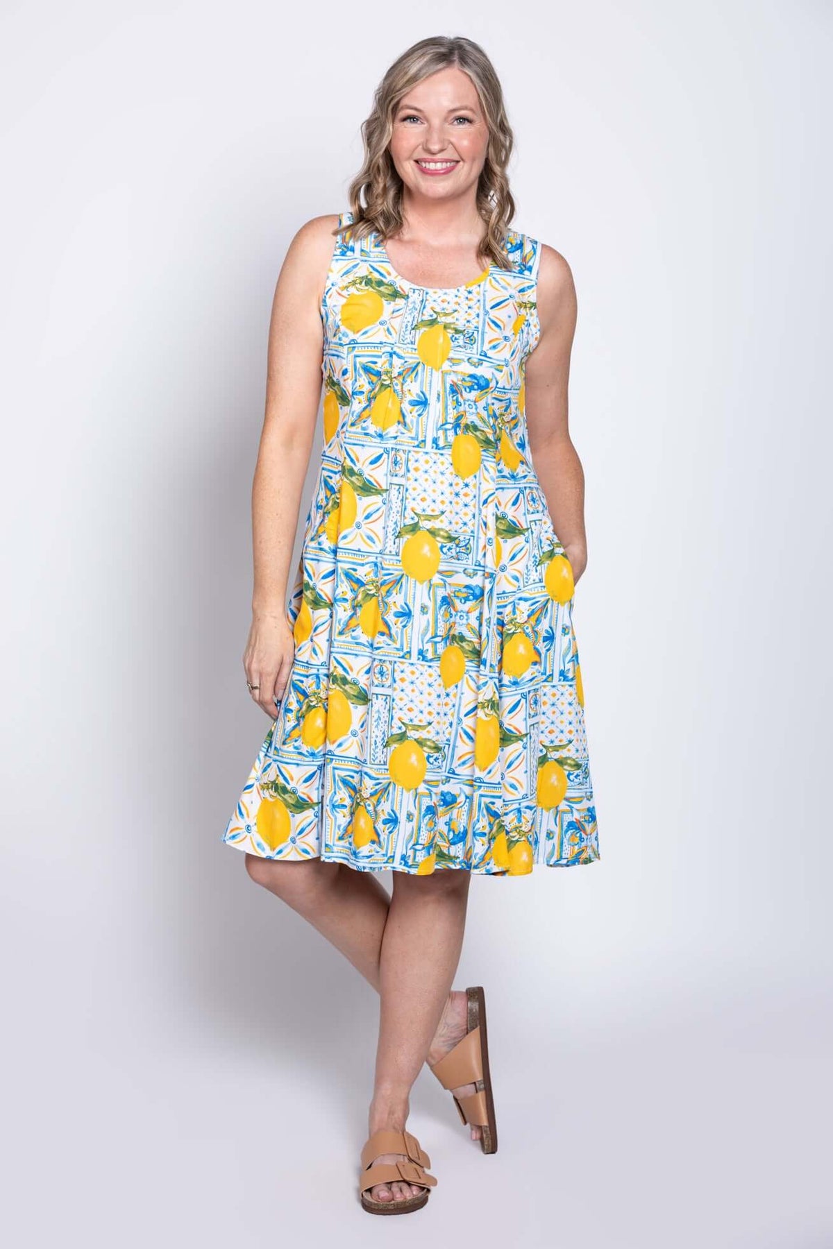 Angled front view of woman posing in sleeveless lemon tile dress