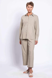 Woman in neutral linen shirt and pants, angled front view