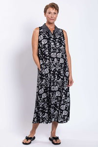 Angled front view showing pockets of a sleeveless black and white floral A-line dress