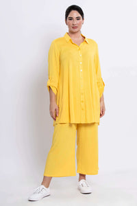 Angled full body view of model in sunflower yellow tunic and matching pants