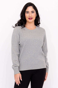 Woman in grey cable knit sweater angled to the side