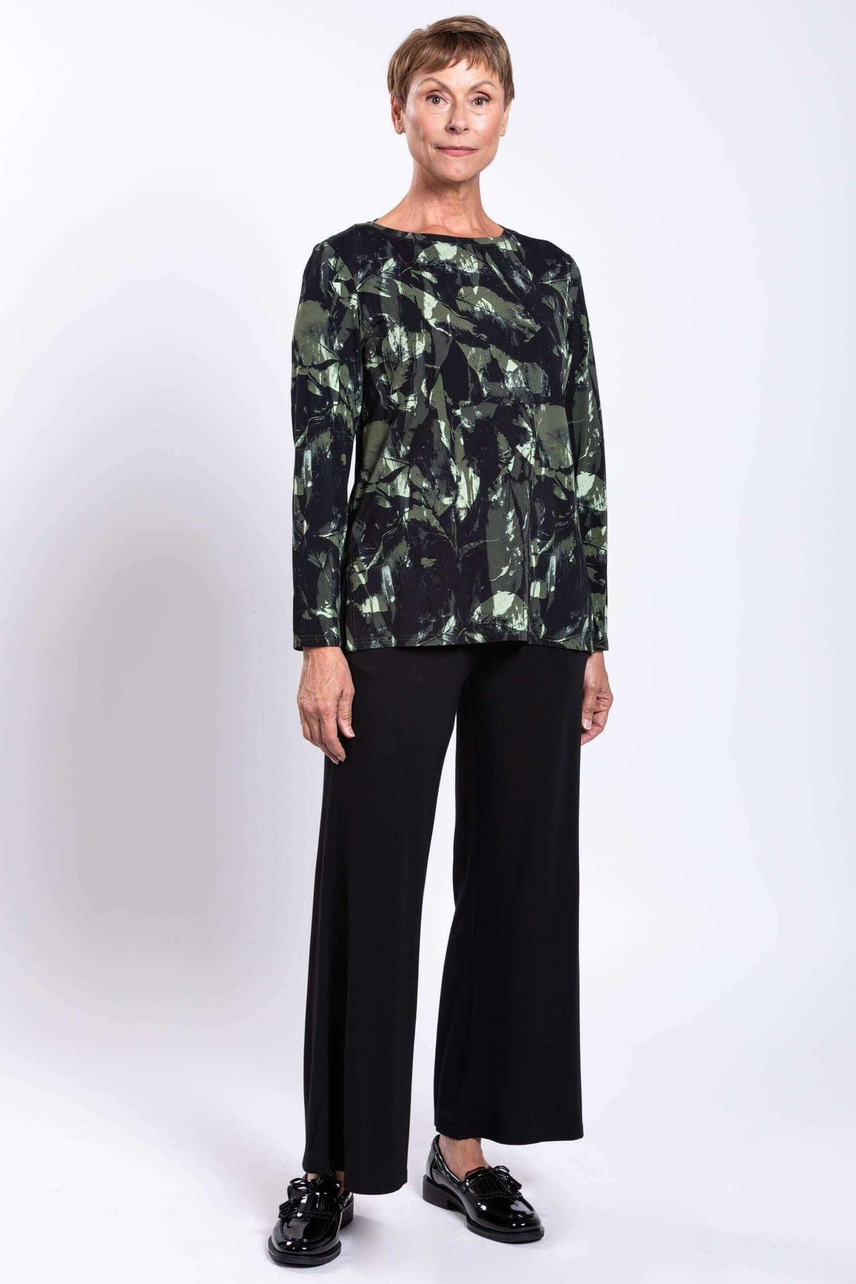Woman standing in forest abstract print longline top with relaxed fit, angled view