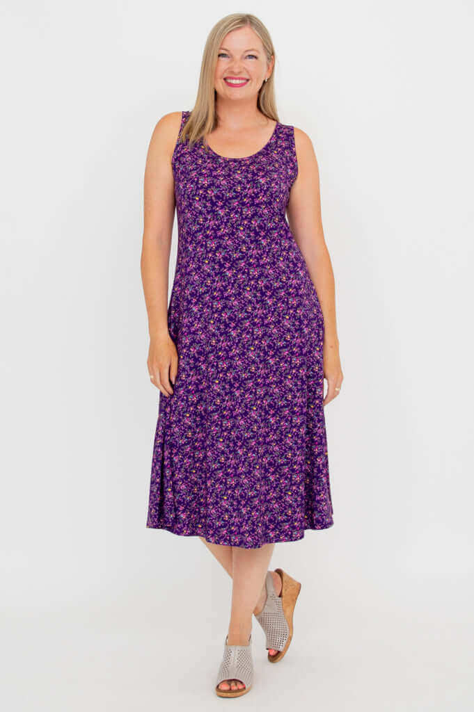Woman modeling Evangelina tank dress in purple floral print, angled forward