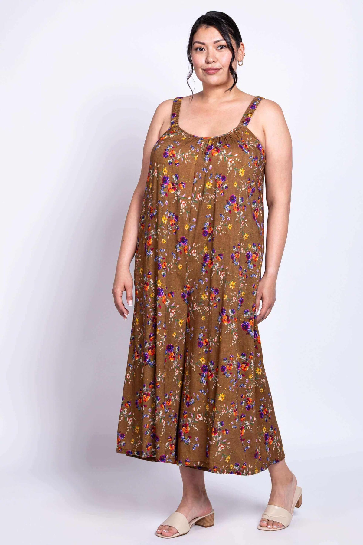 Person wearing a brown floral jumpsuit with sweetheart neckline, angled view