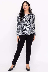 Woman posing in leopard print long sleeve tee and black pants, angled view