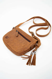 Angled view of brown leather crossbody bag with front zip pocket and tassels