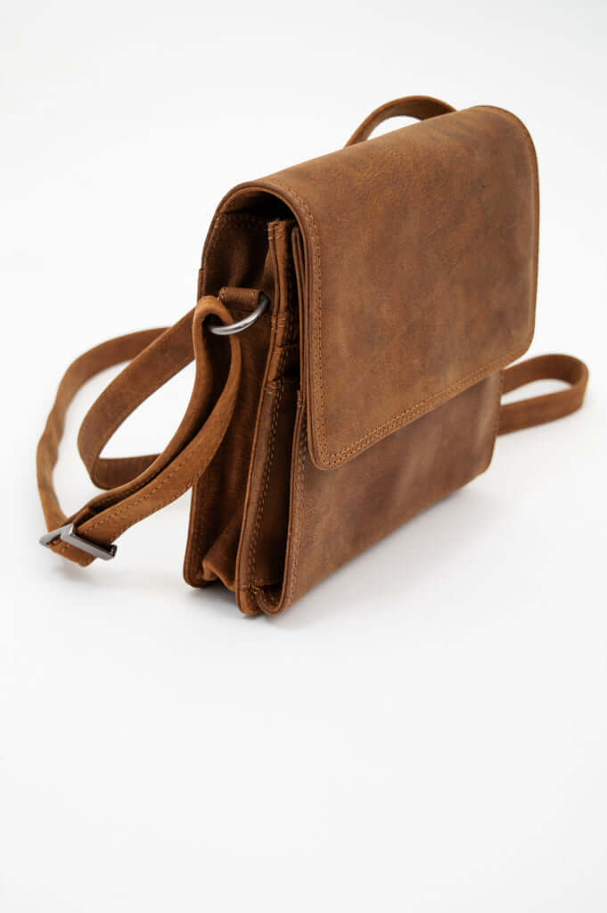 Angled view of brown leather crossbody bag with visible stitching and hardware