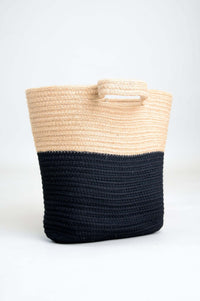 Angled view of a natural and black medium rattan shopper bag with handles