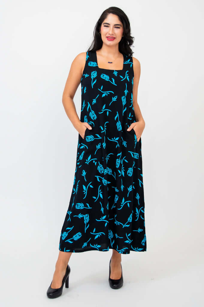 Smiling woman in black ankle-length dress with blue design and pockets