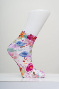 Vibrant pink watercolor floral pattern ankle sock on a white mannequin foot model against a light gray background.