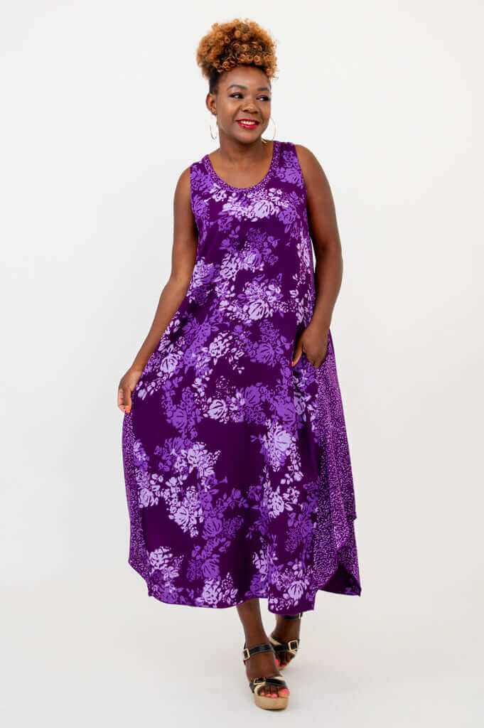 Woman gracefully holding the skirt of her purple floral tank midi dress