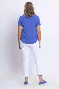 Back view of woman in azure blue bamboo tee and white pants, showing shirt hem