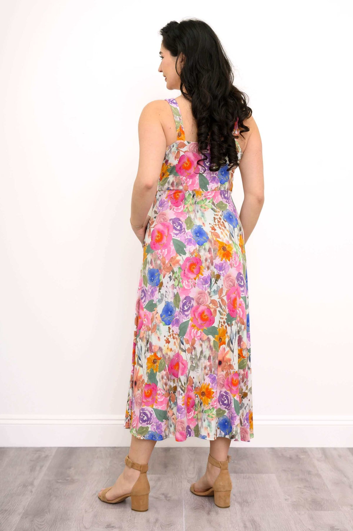 Back view of a woman in a colorful floral fit and flare maxi dress