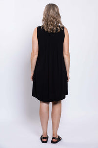 Back view of woman in a sleeveless black A-line dress showcasing pintucked rear panel