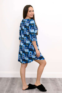 Back angled view of model in blue sleepshirt with dogs and doghouse pattern