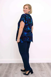 Back angle of woman in black curved-hem tunic with blue floral design
