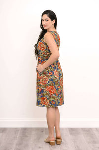 Back angled view of woman in sleeveless floral dress with gathered waist