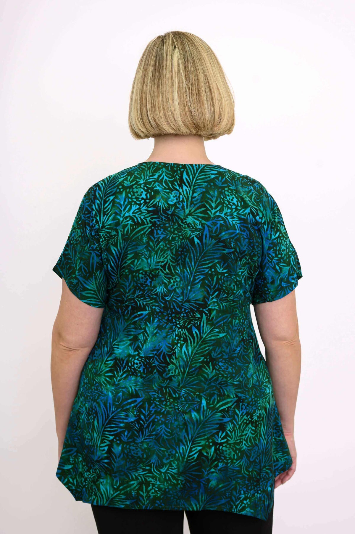 Back view of woman wearing the green and blue leafy print tunic top, showing the full pattern