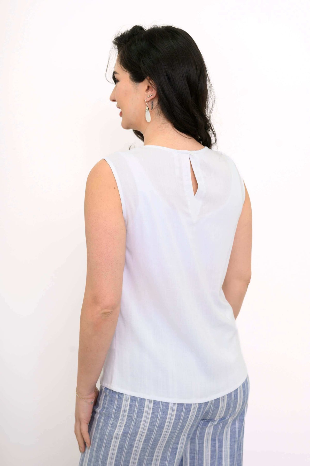 Back view showing keyhole button closure on a white sleeveless tank top