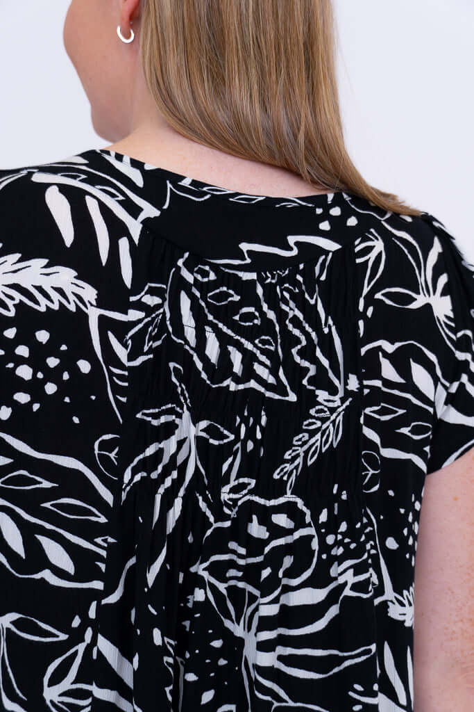 Back neckline and gathers detail on black and white leafy print dress