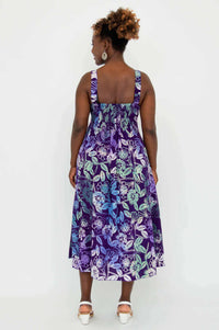 Back view of woman in purple floral empire waist dress showing shirred bodice