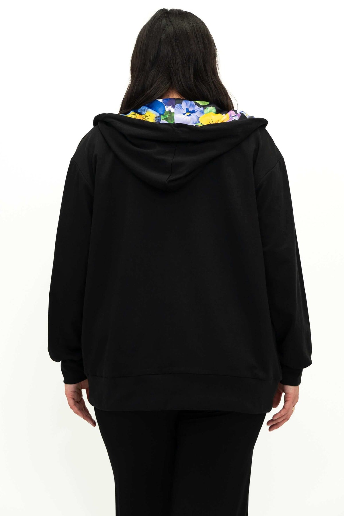 Back view of model in black zip hoody revealing floral lining on the hood