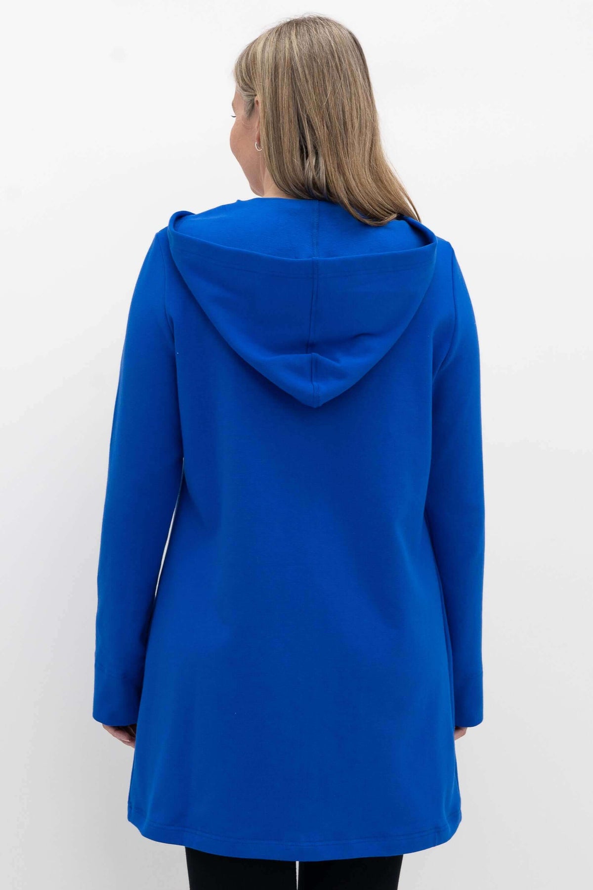 Back view of a woman wearing a blue hooded jacket showing the hood and silhouette