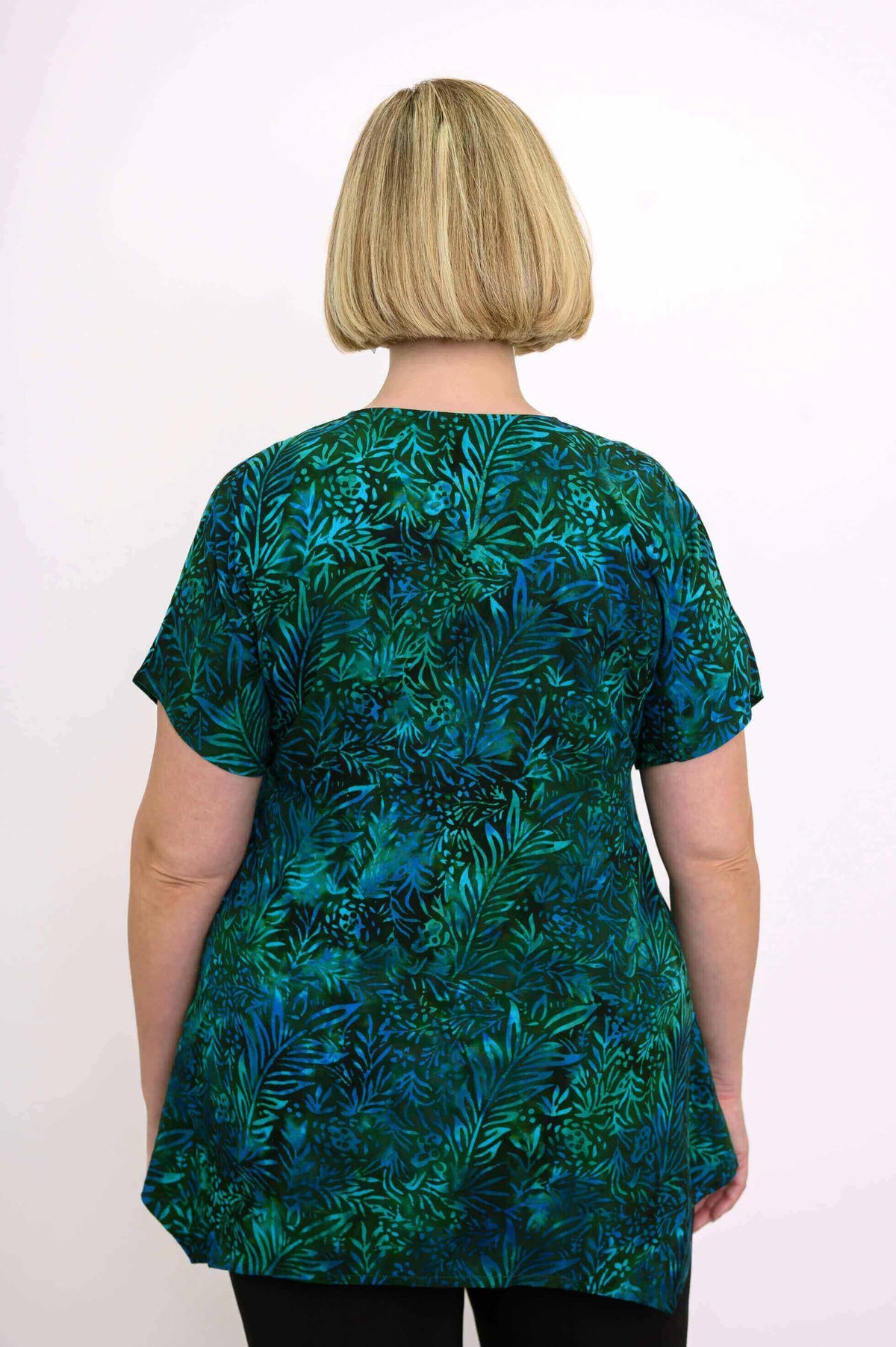 Back view of woman in green and blue leafy print tunic top