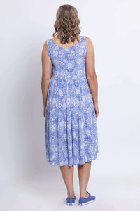 Back view of the sleeveless Juni Dress in blue floral, worn with blue sneakers