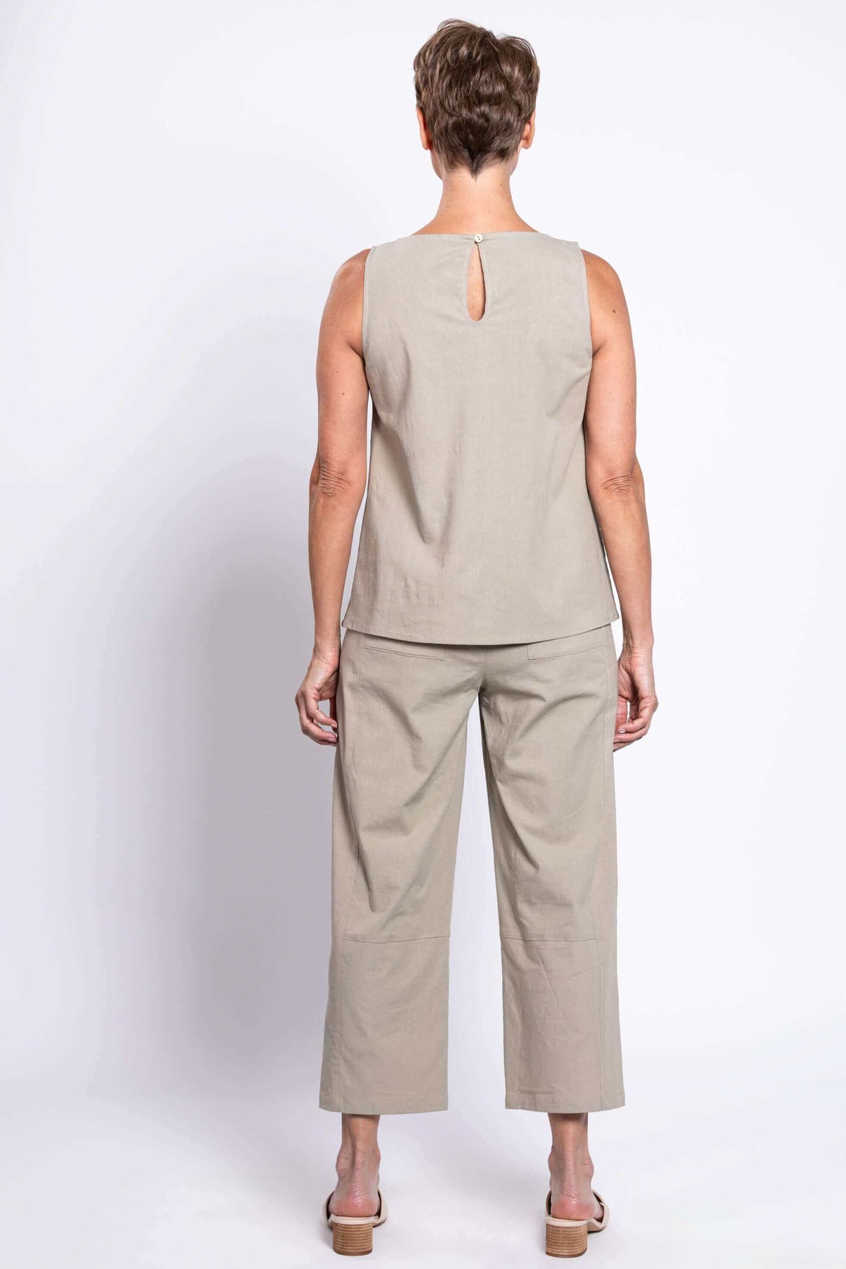 Back view of woman in taupe sleeveless tank top with button closure and matching pants