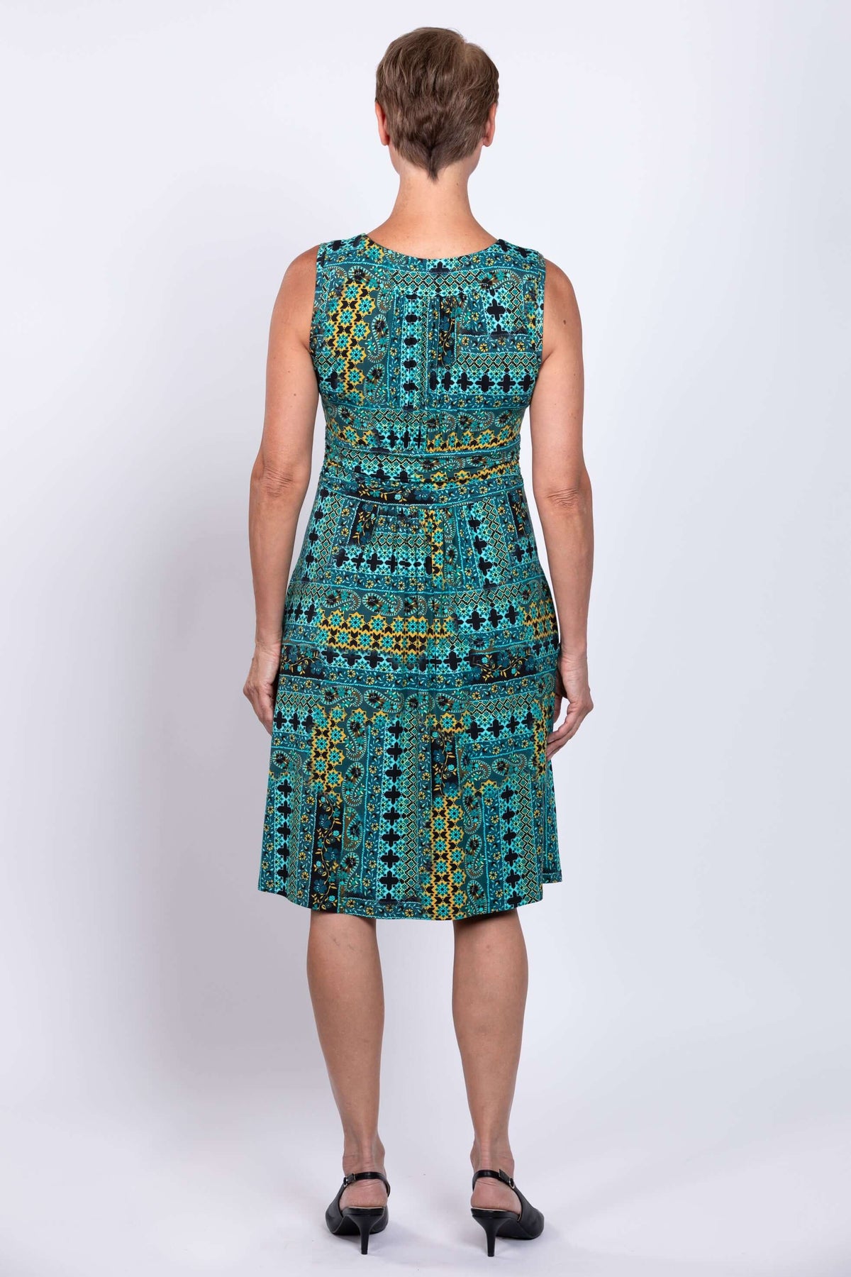 Back view of teal ruched dress showing fitted waistband and dress length