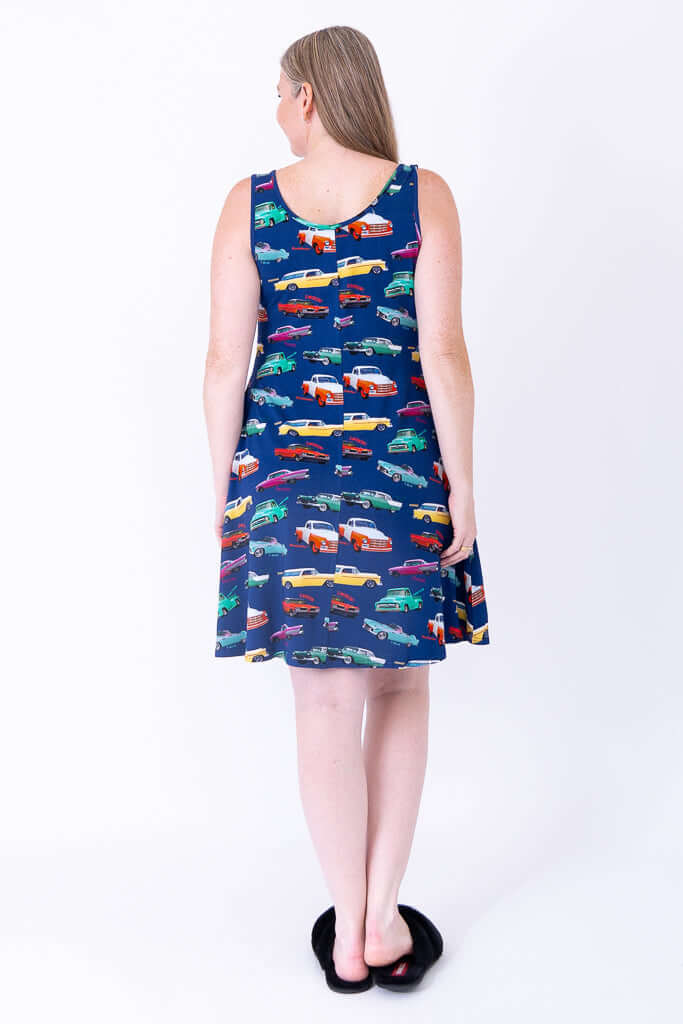 Back view of woman wearing blue sleeveless dress with colorful car print