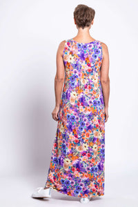 Back view of a woman in a bright and colorful sleeveless floral maxi dress