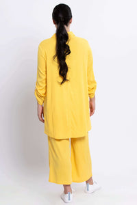 Back view of model displaying the silhouette and drape of the sunflower yellow tunic