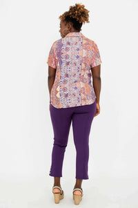 Back view of woman wearing boho mosaic print shirt and purple pants