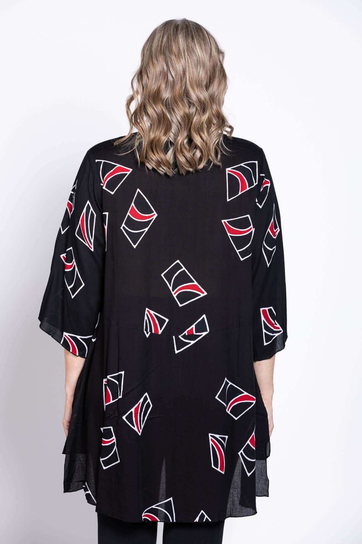 Back view of a woman showing the length and pattern of a black tunic blouse