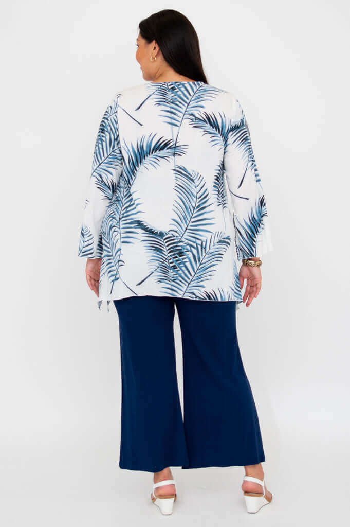 Back view of woman in palm print top and navy pants