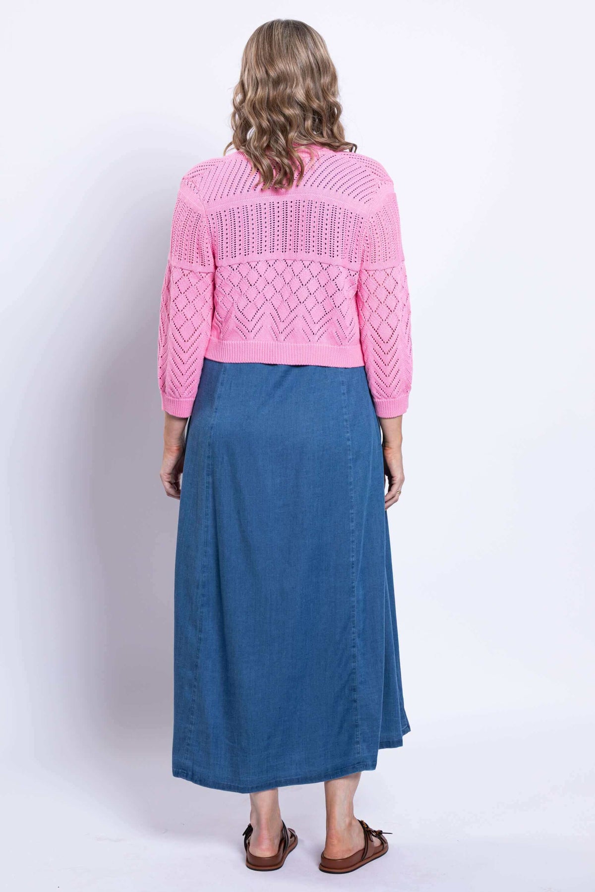 Back view of pink cropped pointelle knit cardigan showing detailed texture