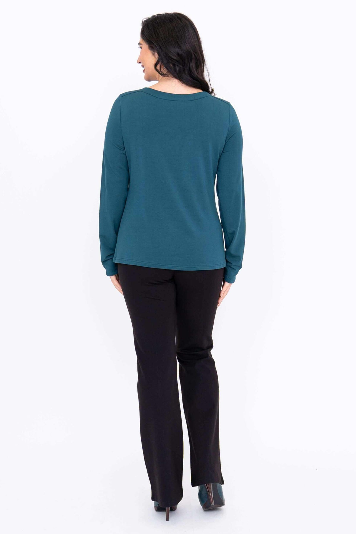 Back view of woman wearing teal Mona boat neck top with long sleeves