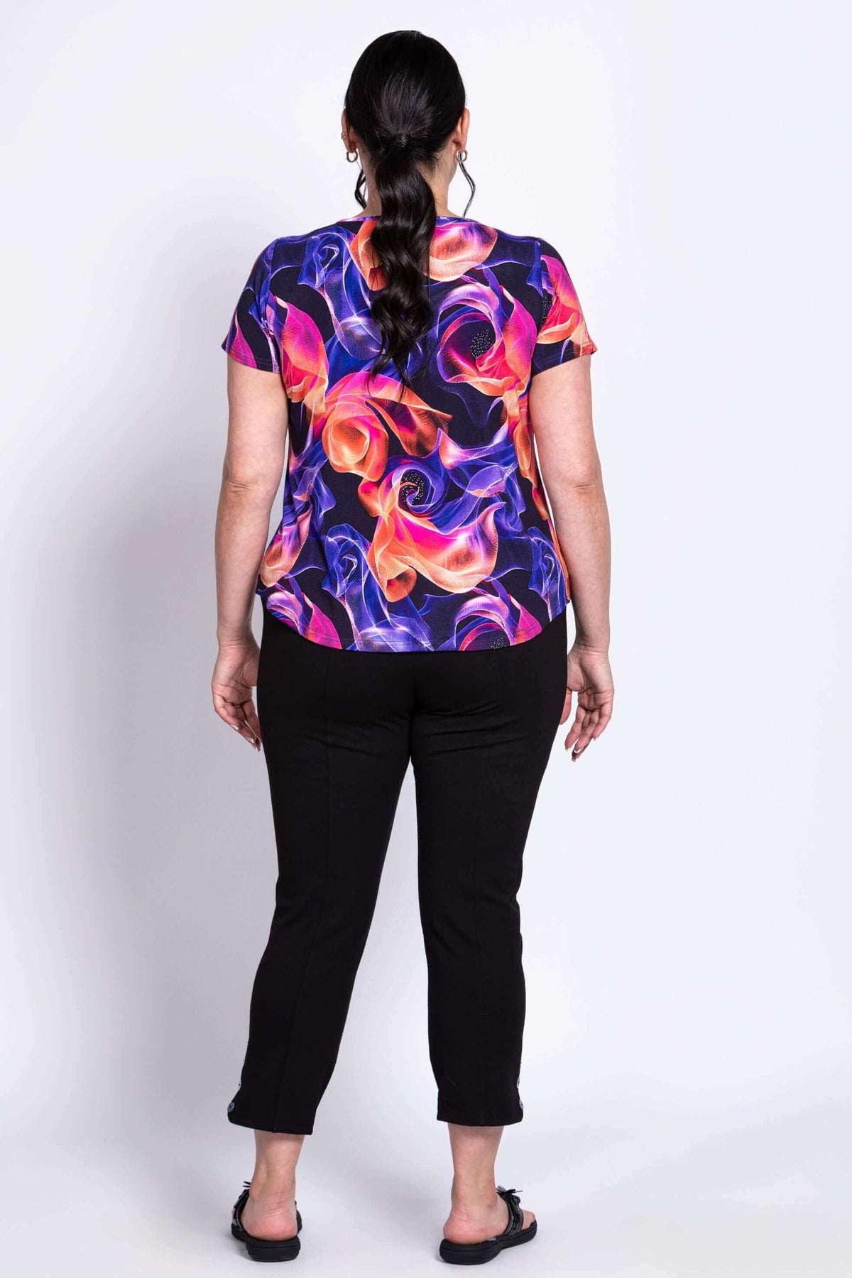 full body back view of short sleeve top with rounded hem and orange and purple swirl pattern