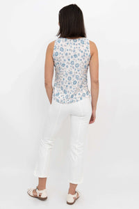 Back view of woman wearing a blue floral tank top and white pants