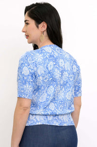 Back view of a blue floral short sleeve knit cardigan on a woman