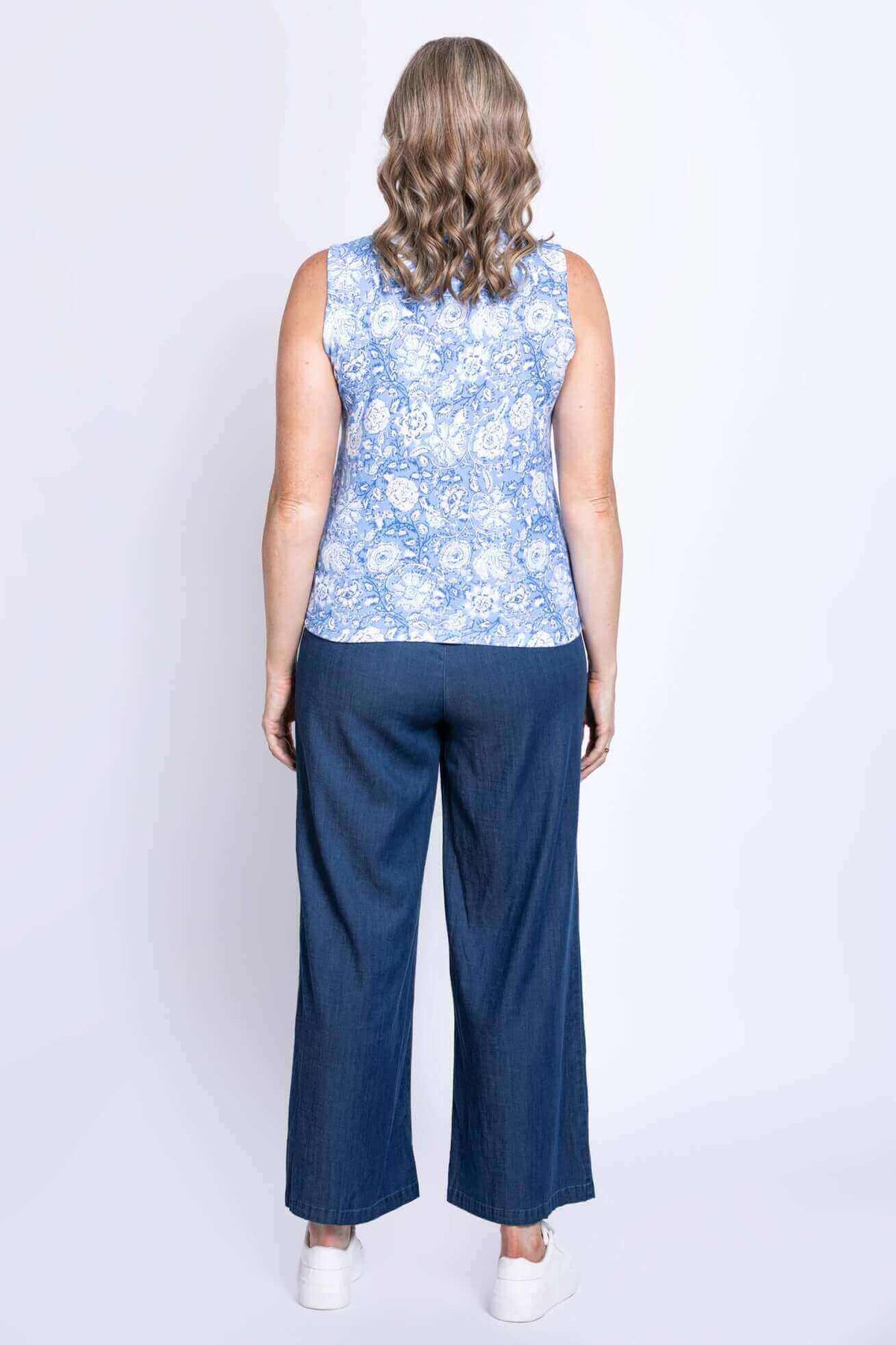 Back view of woman showcasing blue floral tank top with blue pants