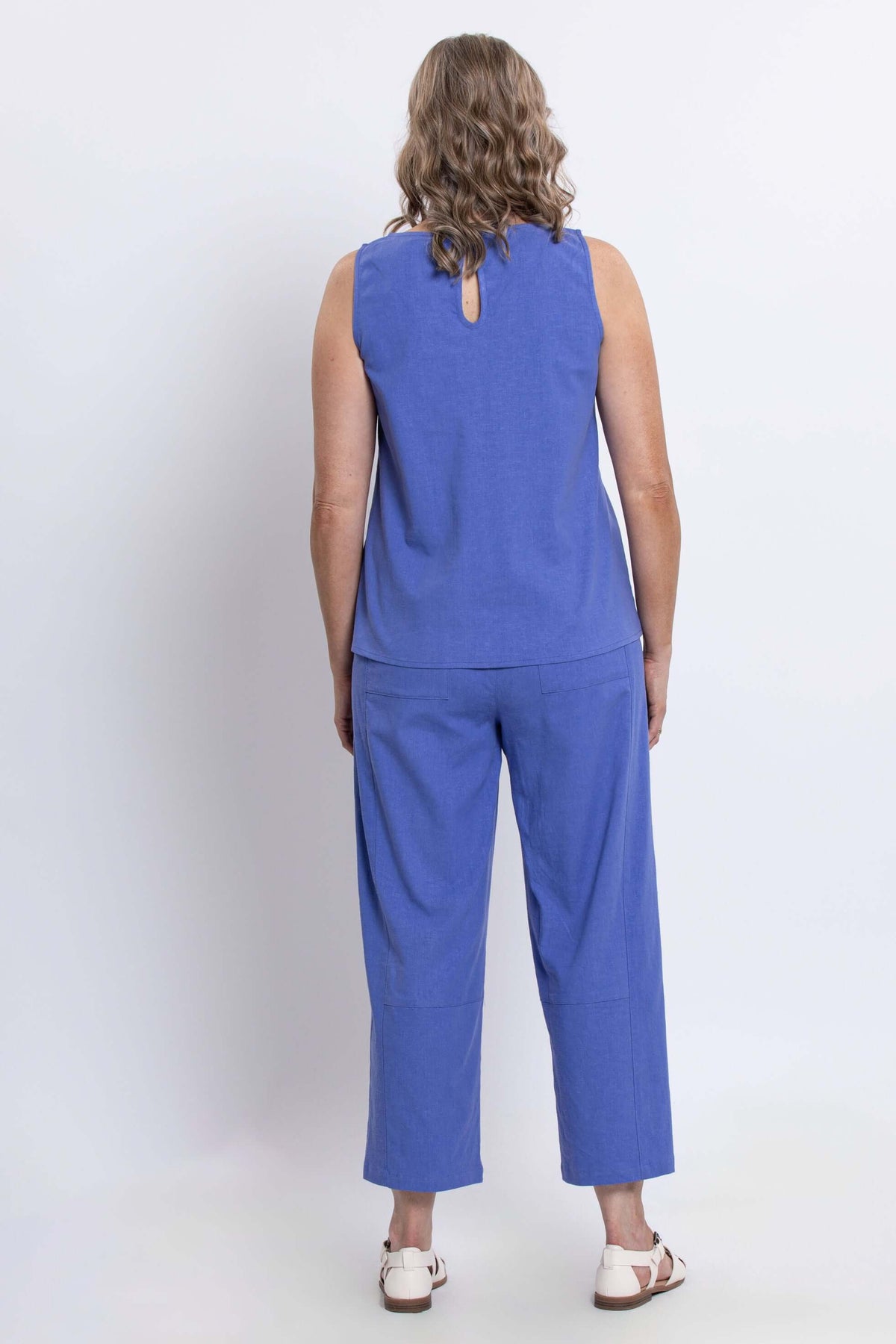 Back view of woman wearing blue tank top showing back button detail