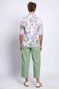 Back view of a woman in a floral print blouse and light green pants