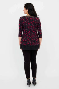 Back view of woman wearing floral mesh tunic and black fitted pants