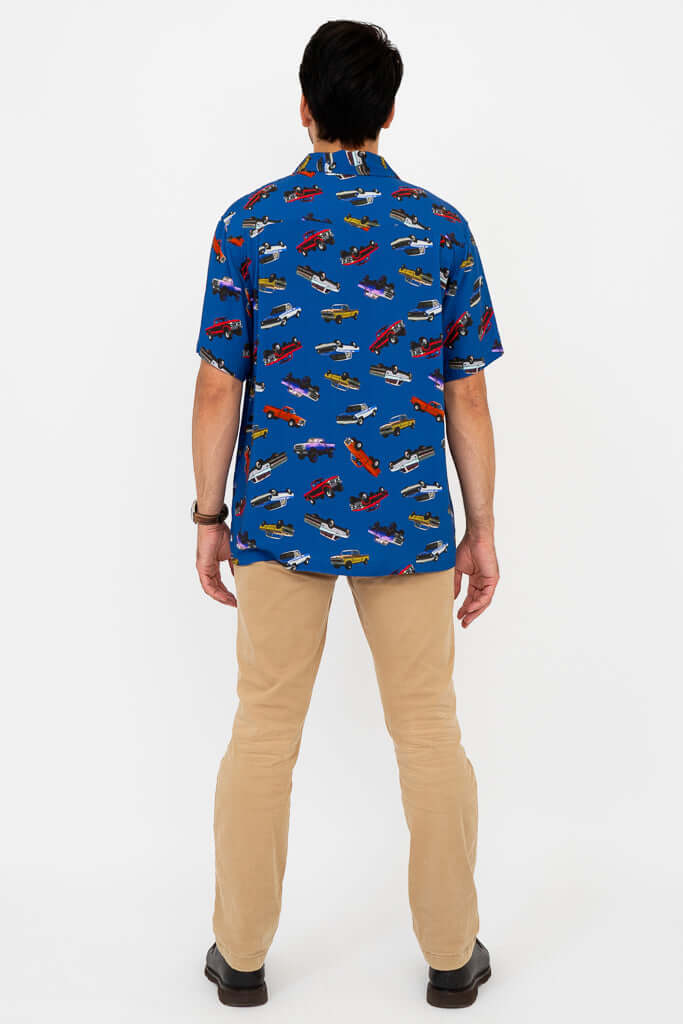 Back view of man in blue monster truck print shirt and khaki pants
