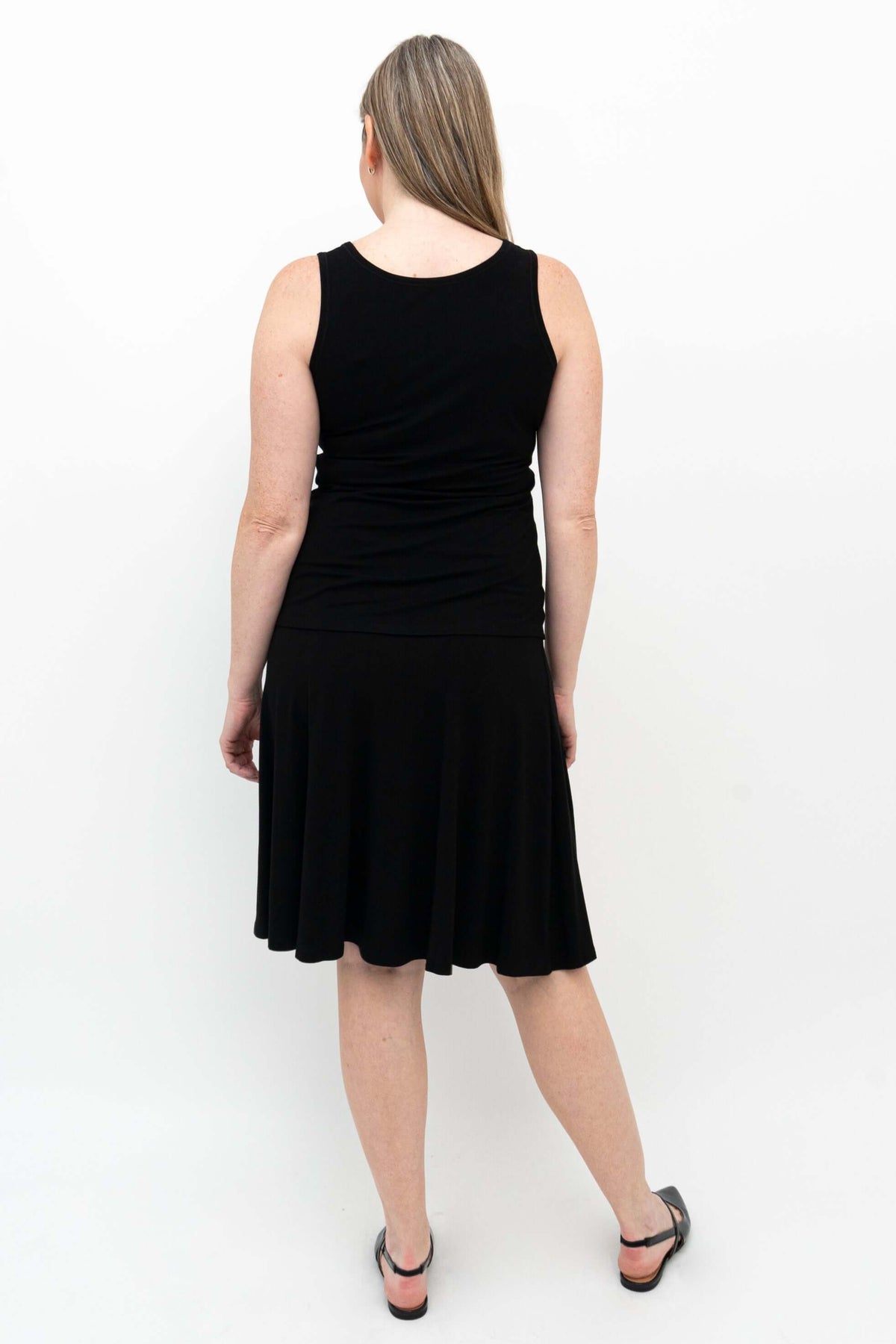 Back view of Aly fit and flare black skirt on model