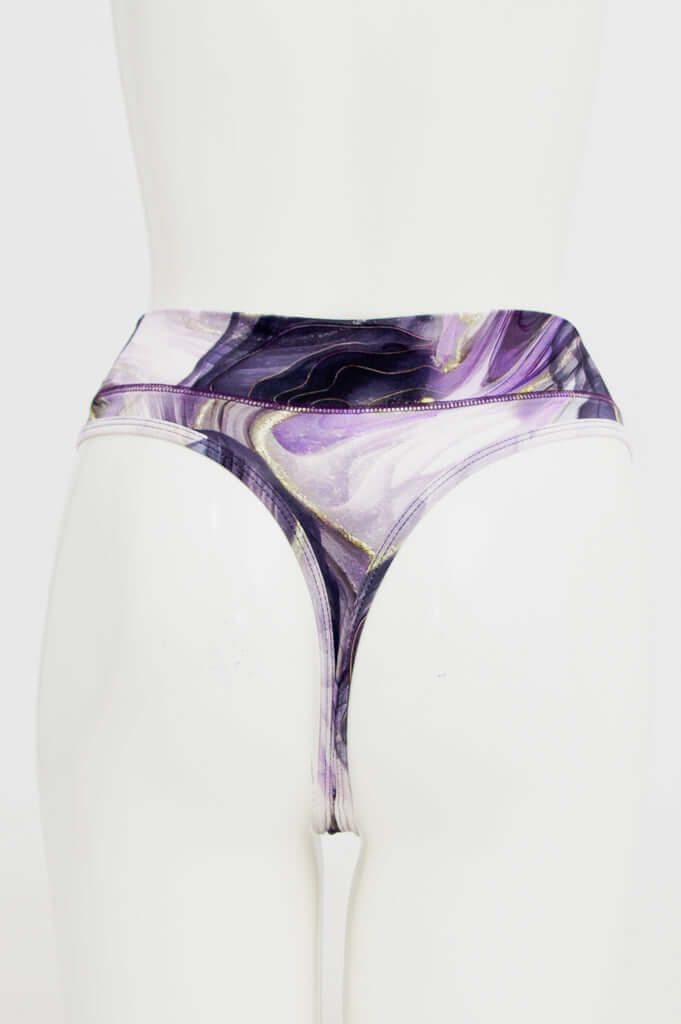 Back view of high-rise thong underwear in purple and gold abstract print on mannequin